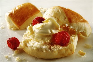 Traditional scone with clotted cream and raspberries