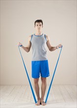 Young man doing fitness exercises with a resistance band
