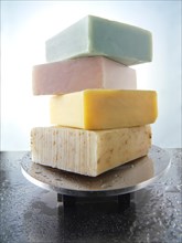 Bars of hand-made soaps piled on a soap dish