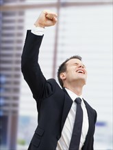 Businessman in an office cheering with a clenched fist