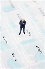Businessman miniature figurine on pill box