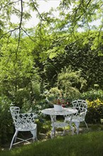 White metal garden table and chairs in a residential backyard