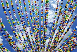 Colourful paper garlands against a blue sky