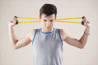 Young man doing fitness exercises with an expander