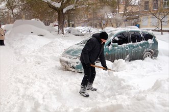 Man removing snow from car