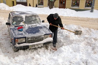 Man clearing car from snow