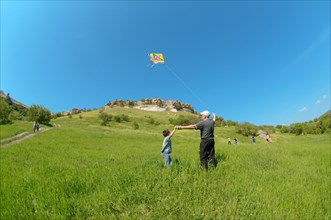 Grandfather and grandson flying a kite