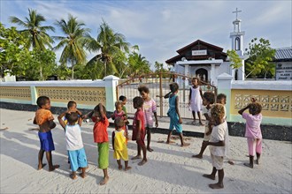 A group of children standing in front of a church