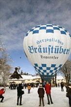 White and blue hot air balloon with advertising of 'Herzogliches Braeustuebel' restaurant