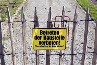 Sign on a picket fence 'Betreten der Baustelle verboten!'