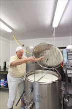 Cheesemaker during the production of goat cheese at the Goas-Alm cheese factory