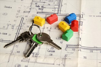 House keys and miniature houses on a construction plan