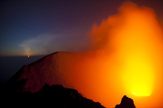 Moonset at the crater of the boiling lava lake of Mount Nyiragongo volcano