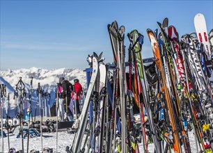 Skis and snowboards leaning against ski racks