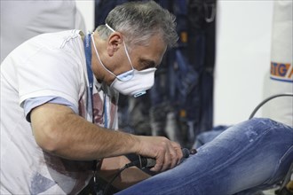 Jean production at the stand of 'Pepe Jeans'