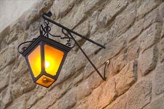 Street lamp on a stone wall