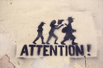 Graffiti on a wall 'Attention!' as a warning against pickpocketing in Lisbon