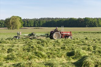 Tractor with hay turning machine