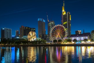 The traditional Main Festival with rides and ferris wheel in front of the Frankfurt skyline