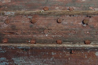 Weathered planks of a boat with residues of red paint