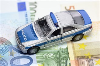 Miniature police car on euro banknotes