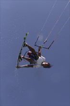 Kitesurfer jumping with splashing water