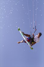 Kitesurfer jumping with splashing water