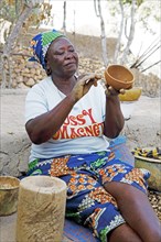 Woman of the Kapsiki ethnic group drawing patterns on a bowl made of clay