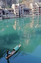 Houses and a fisherman in a boat on the jade-coloured Wuyang River