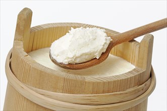 Cream on a wooden spoon in a traditional wooden pail