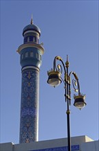 The blue minaret of Rasool Azam Mosque and a streetlamp at the Corniche of Muttrah