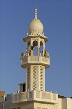 The white minaret of a small mosque