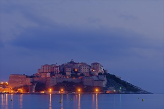 The citadel (castle) of Calvi surrounded by the mediterranean sea at the blue hour before sunrise. Calvi is in the department Haute-Corse