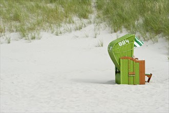 Green roofed wicker beach chair on the beach