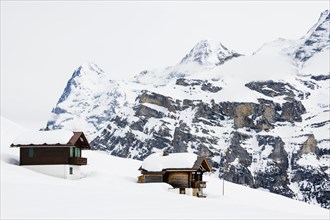 Old log cabins in the Bernese Oberland with Mt Eiger in winter