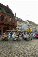 Wine stand and restaurants in front of the Historical Merchants Hall on Muensterplatz square or Cathedral Square