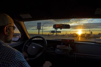Taxi driver and the Manhattan skyline at sunset