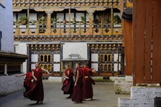 Group of young monks practicing a religious dance in the courtyard of Mongar Dzong fortress