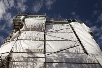 Building with scaffolding and tarpaulins