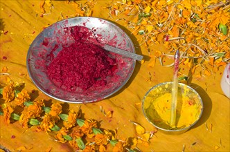 Colourpowder and coloured rice on yellow material to work with as a priest