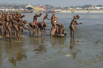 Group of new sadhus praying in the river Ganges as part of their initiation