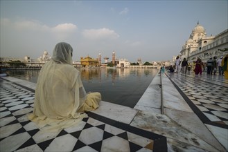 A Sikh devotee sitting at the holy pool