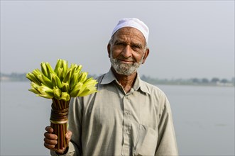 A local man holding a bunch of water lilies (Nymphaeaceae)