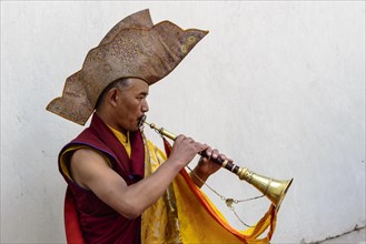 Monk making music as part of the opening ceremony of the Hemis Festival