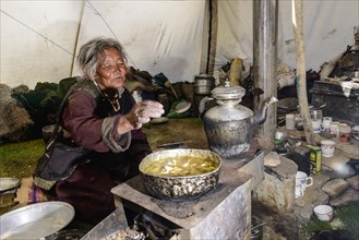 Nomad woman preparing food inside her tent