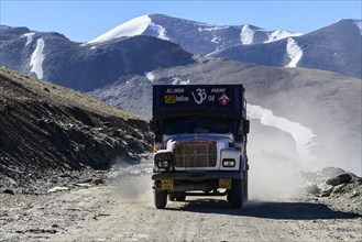 A truck driving on the dusty winding road leading up to Taglang La