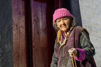 An old Ladakhi woman holding her mala