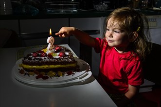 Girl pointing to the candle on her birthday cake