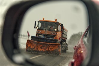 View of a snowplough in a car's wing mirror