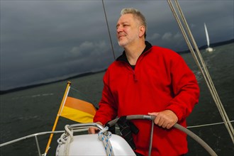 Skipper standing at the helm of his yacht